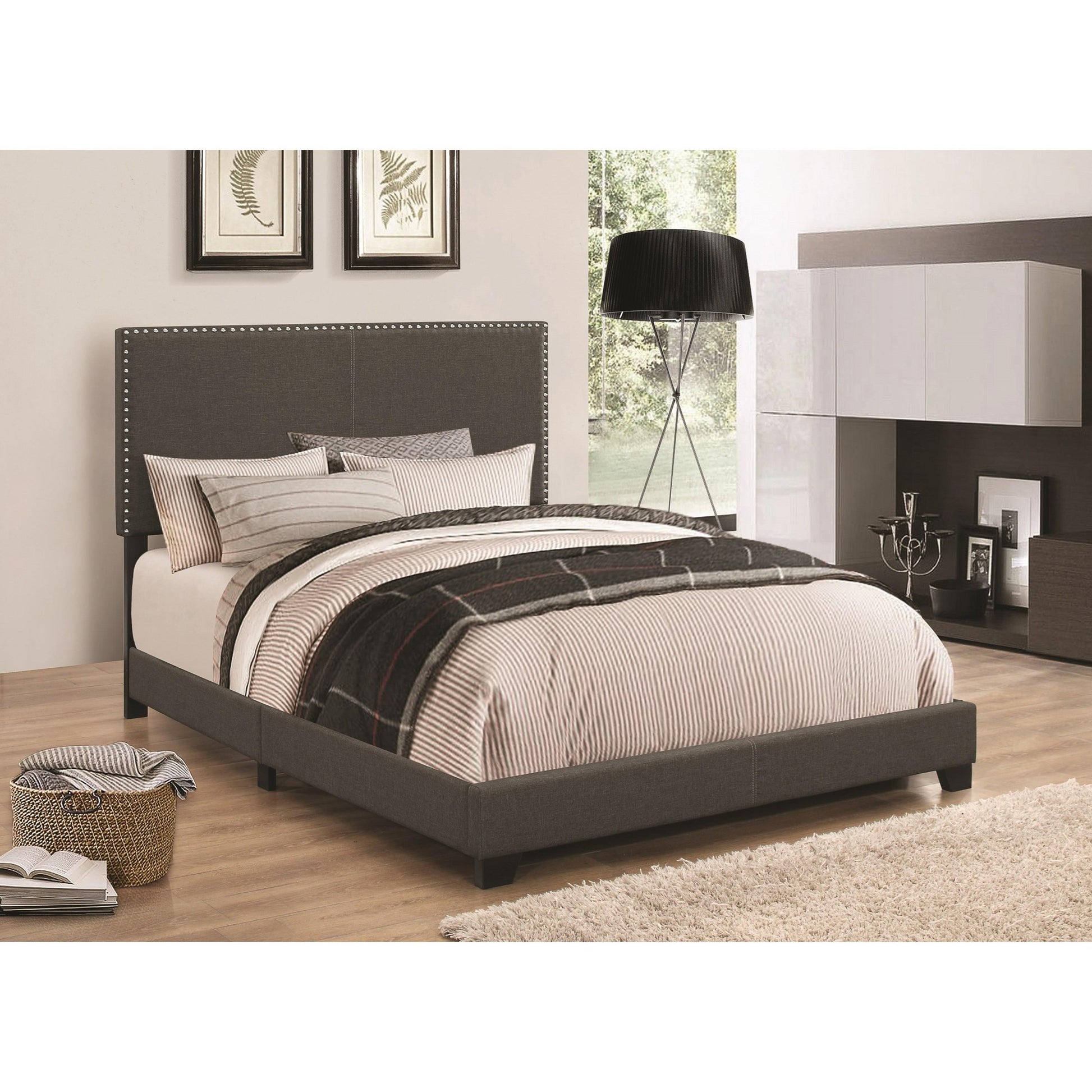 Cal King upholstered bed in espresso with a studded headboard and neutral-striped bedding in a modern bedroom scene.