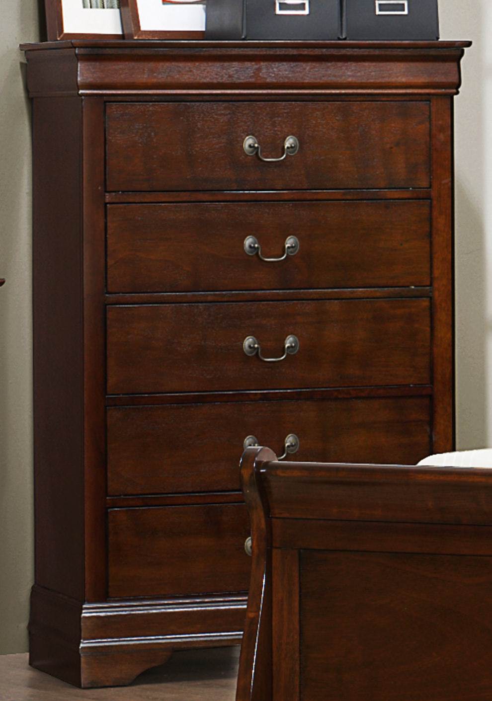 5-drawer cherry-brown wooden chest with metal hardware in a bedroom.