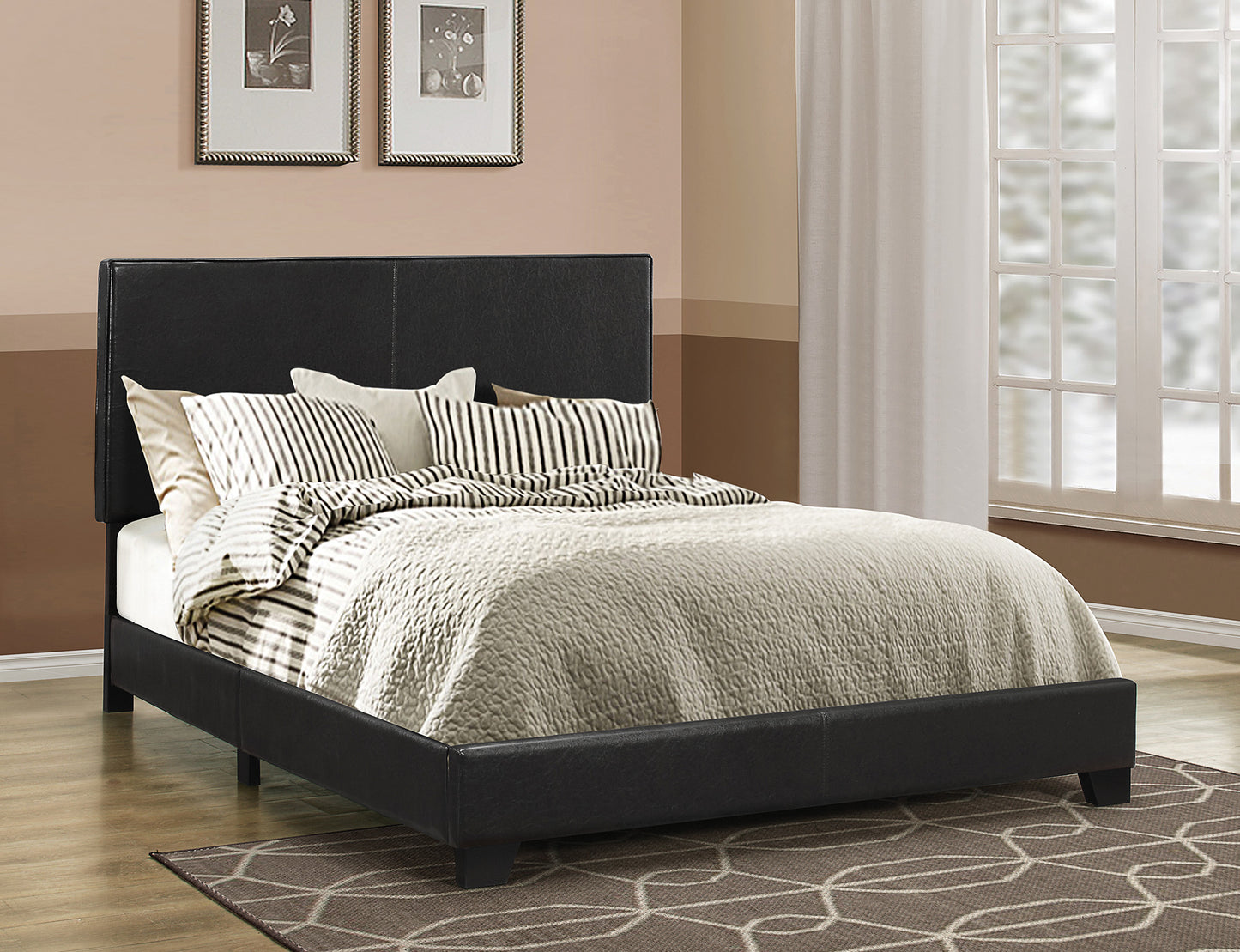 Leather upholstered queen-size platform bed in black with striped bedding