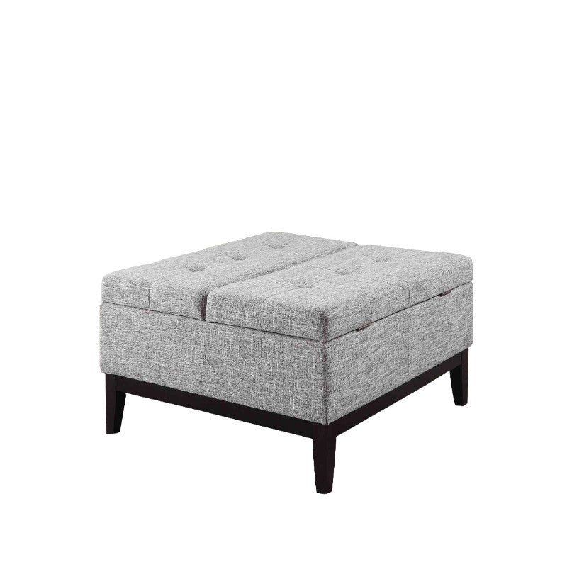 Fabric upholstered tufted square storage coffee table ottoman in gray with dark wood legs.