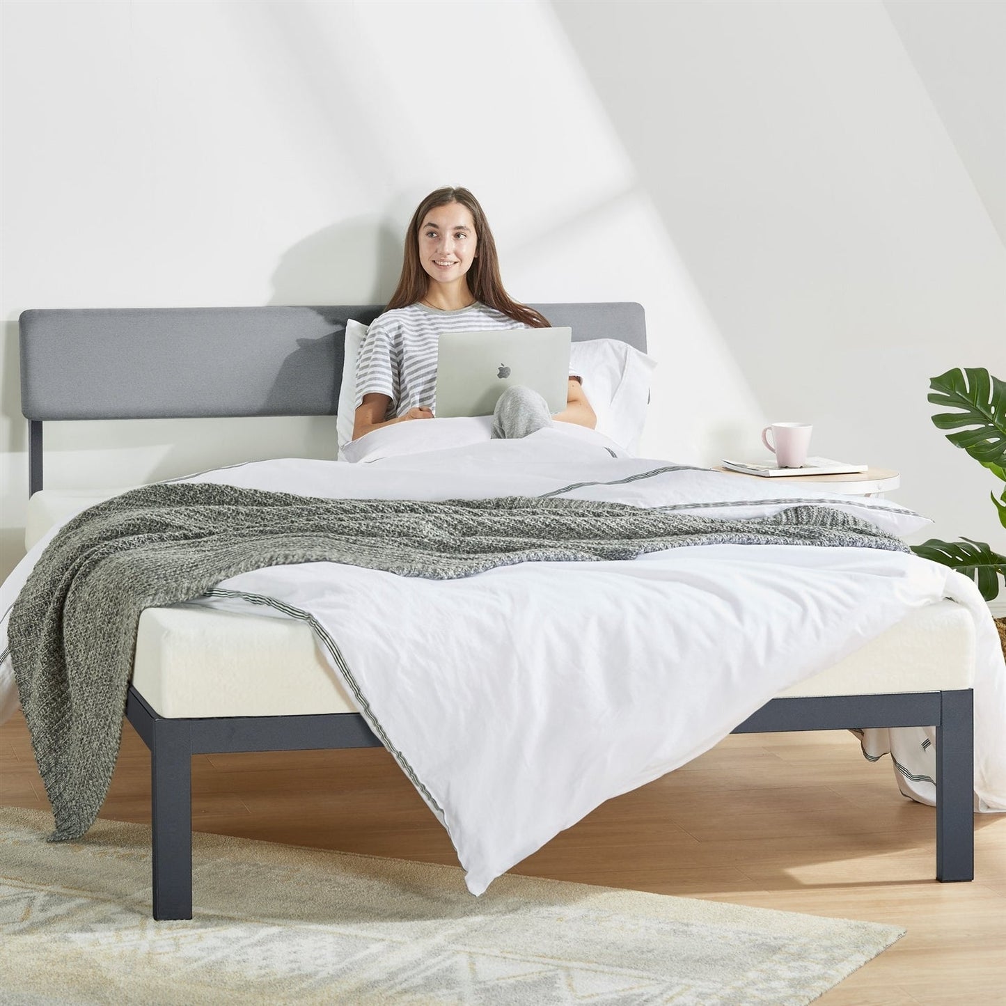 King size gray soft-fabric platform bed with metal headboard and wooden slats, dressed in white linens.
