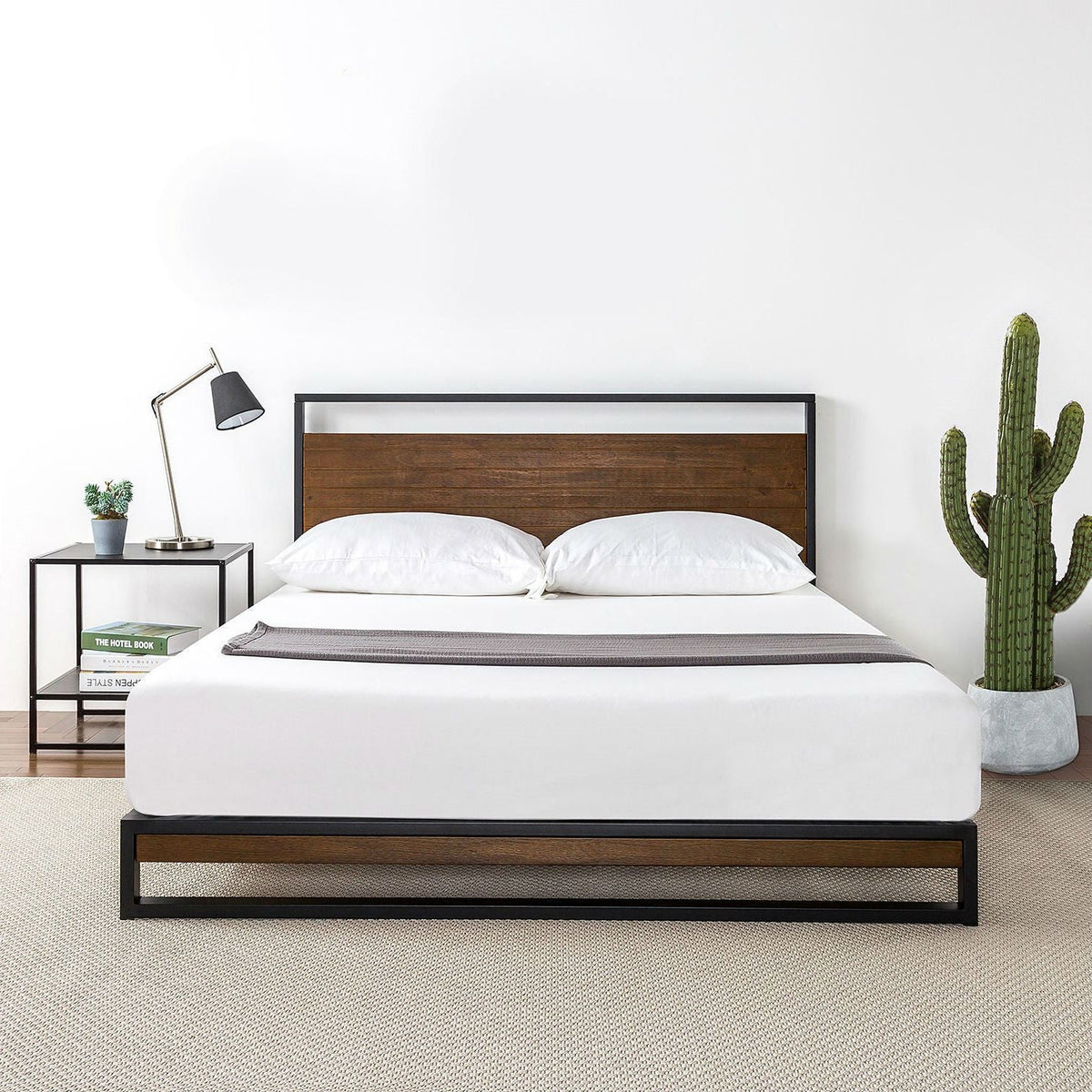 Full-size metal-wood platform bed frame with headboard; black metal frame and brown wood panel, white bedding.