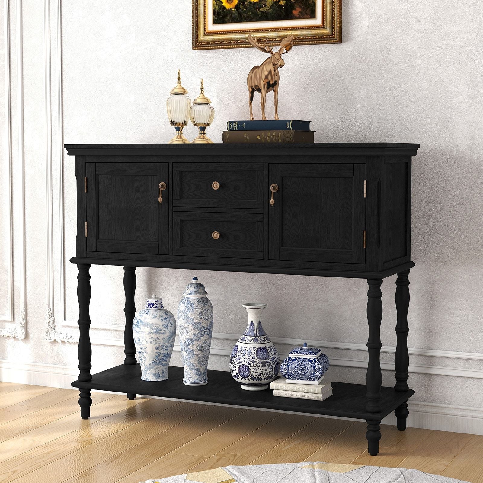 Retro black wooden console table with 2 drawers and 2 cabinets, gold hardware, lower shelf with blue-and-white vases.