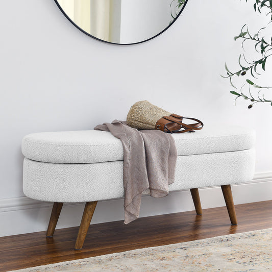 Oval white storage bench with textured upholstery and rubber wood legs (43.5x16x16 in)