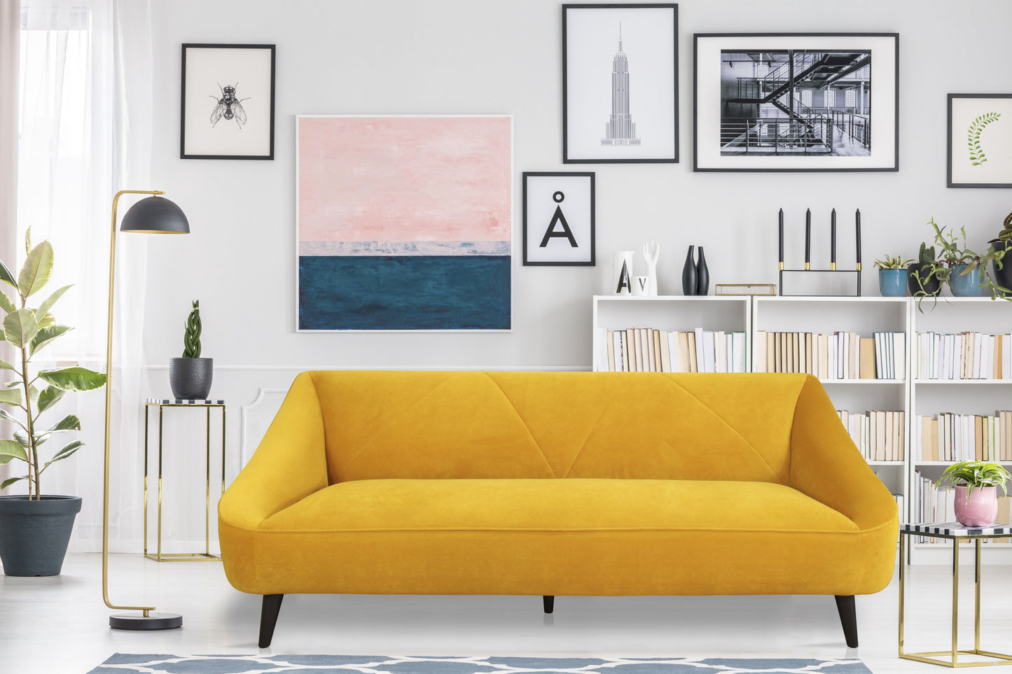 BAYLEE SOFA MAIZE YELLOW in a modern living room with a gallery wall and greenery.