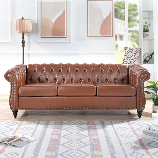 Brown PU leather Chesterfield three-seater sofa with rolled arms and nailhead trim.