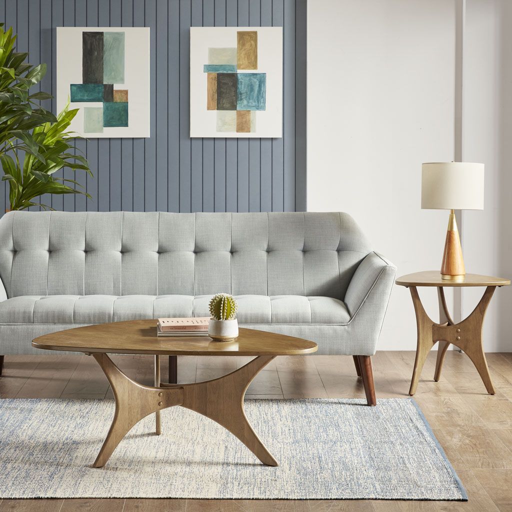 Doba Triangle Wood Coffee Table with curved pedestal legs in natural wood finish, in a modern living room.