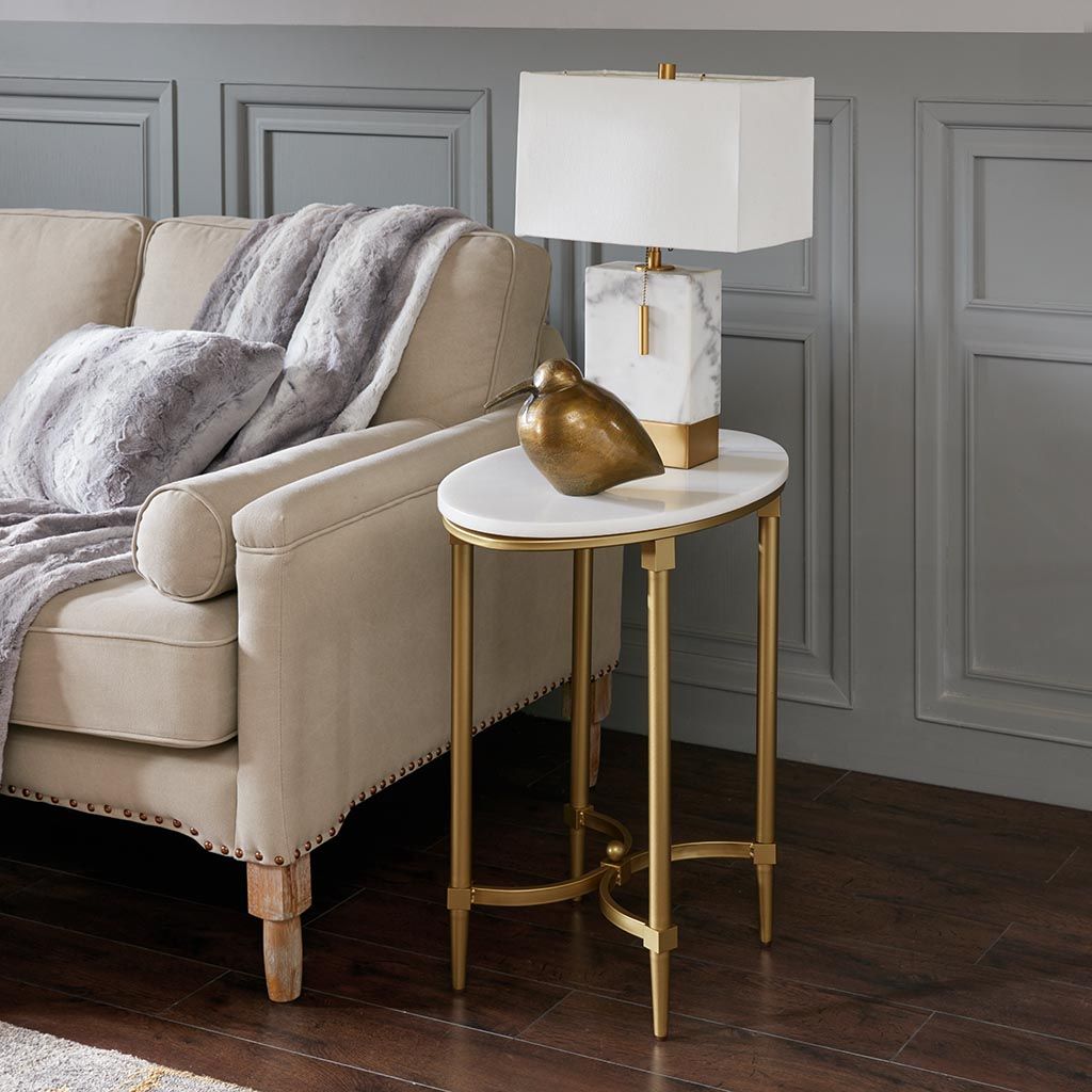 Bordeaux end table with oval white marble top and gold metal legs.