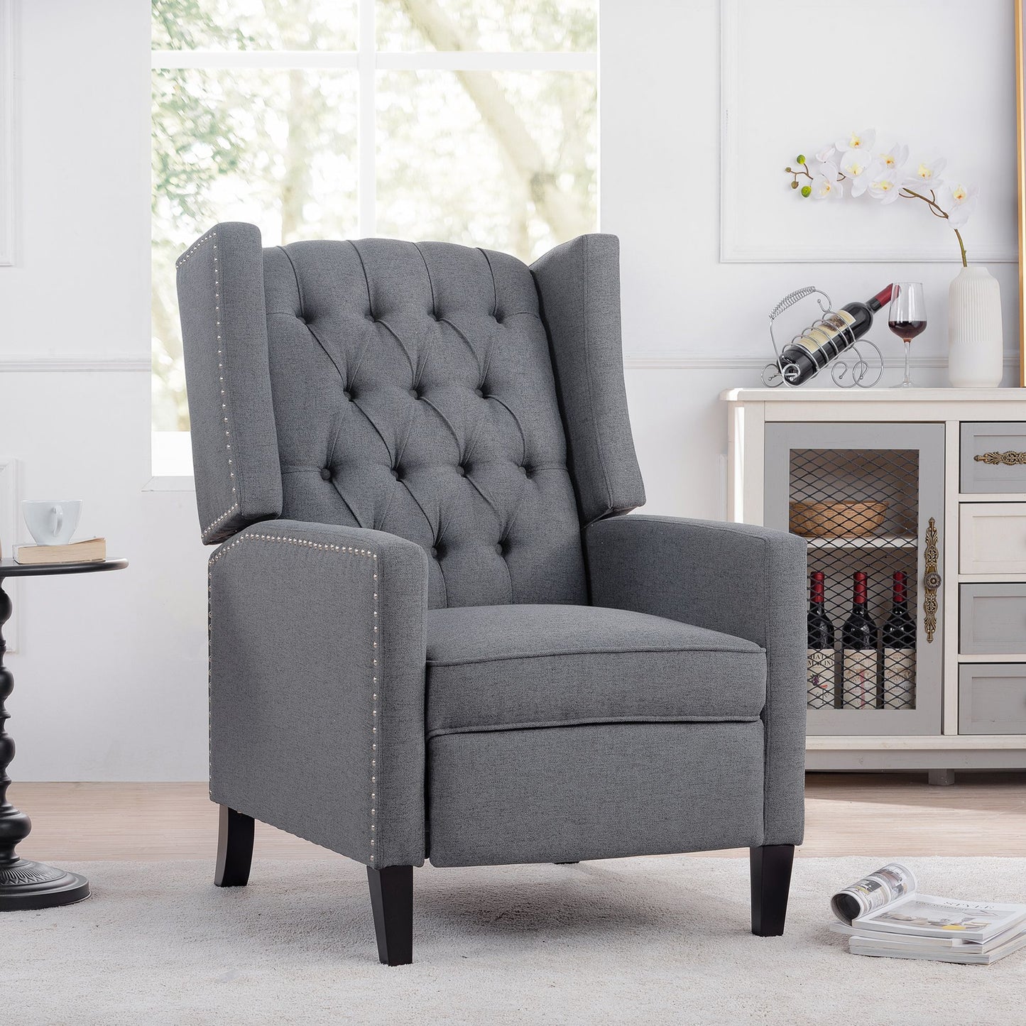 27.16-inch wide manual wing chair recliner in gray fabric with tufted back and nailhead trim.