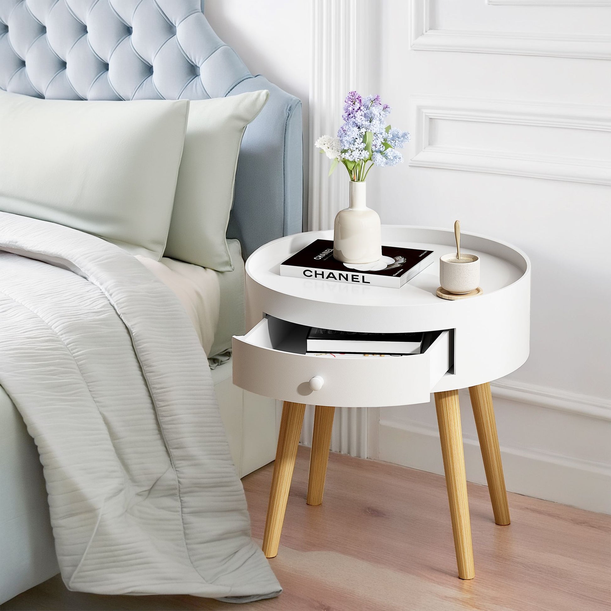 18-inch white round nightstand with storage drawer and oak legs, Chanel magazine on top