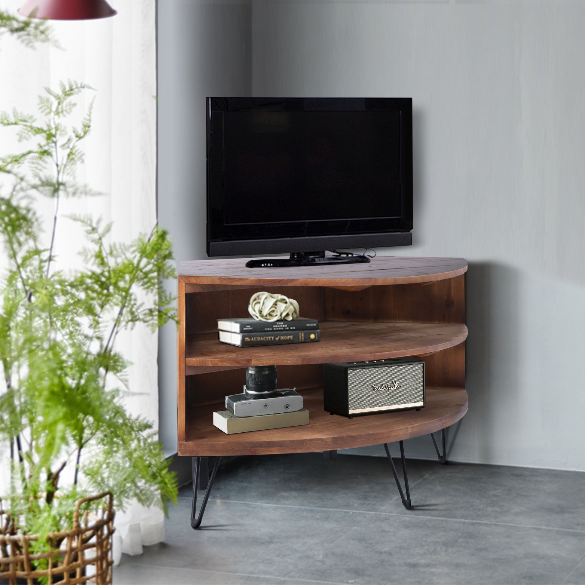Fan-shaped reclaimed wood corner media table with TV on top and Marshall speaker on lower shelf, by Doba.