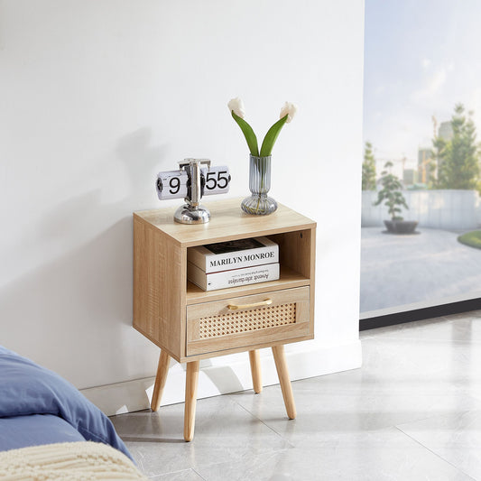 Rattan end table with drawer and solid wood legs in natural finish, shown with a clock and tulip vase.