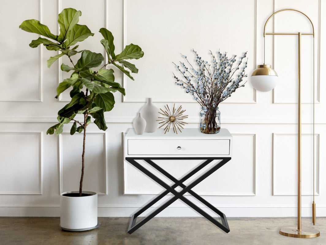 Koda 23-inch white wooden end table with glass top, single drawer, and black metal cross base