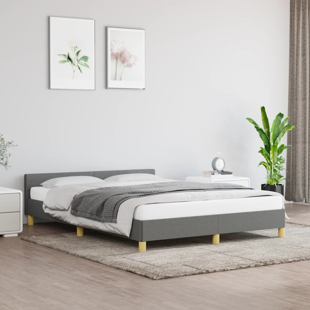 Bed frame with headboard in dark gray upholstery and light wood legs.