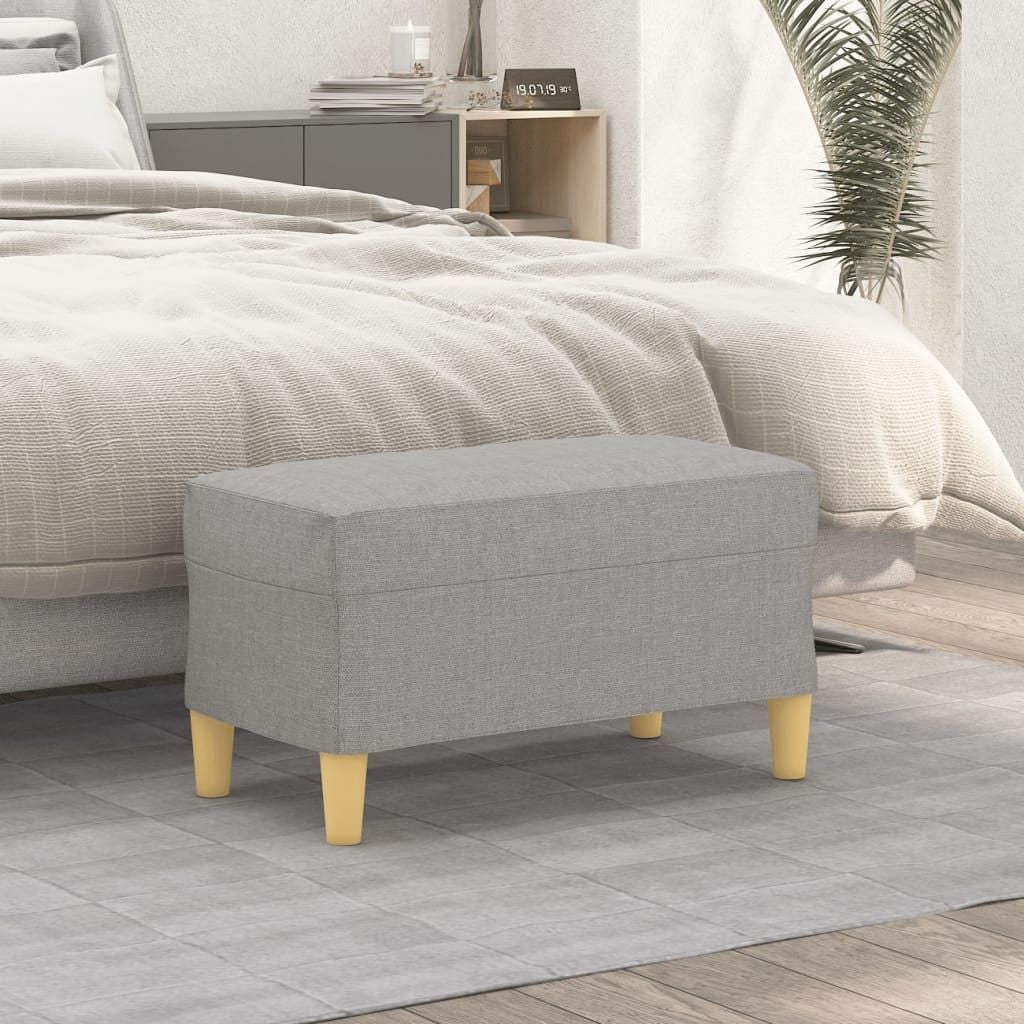 Light grey fabric bench ottoman with natural wood legs in a modern bedroom