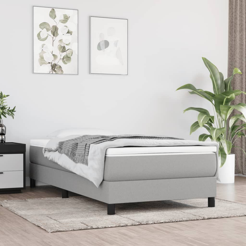 Twin XL bed frame in light grey fabric with a low-profile platform and black legs