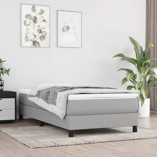 Twin XL bed frame in light grey fabric with a low-profile platform and black legs