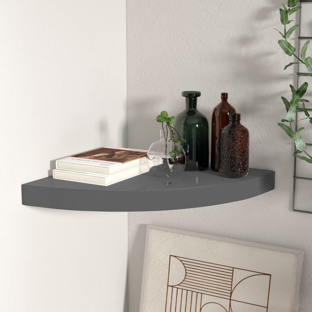 Floating corner shelf in high-gloss grey MDF with metal accents; holds 2 books, glass vase, and brown/green bottles.