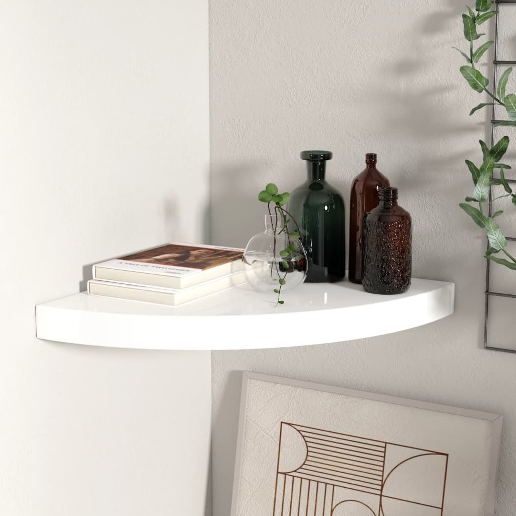 Corner shelf in high-gloss white, curved edge corner unit with two books, glass vase with plant, and brown/green bottles