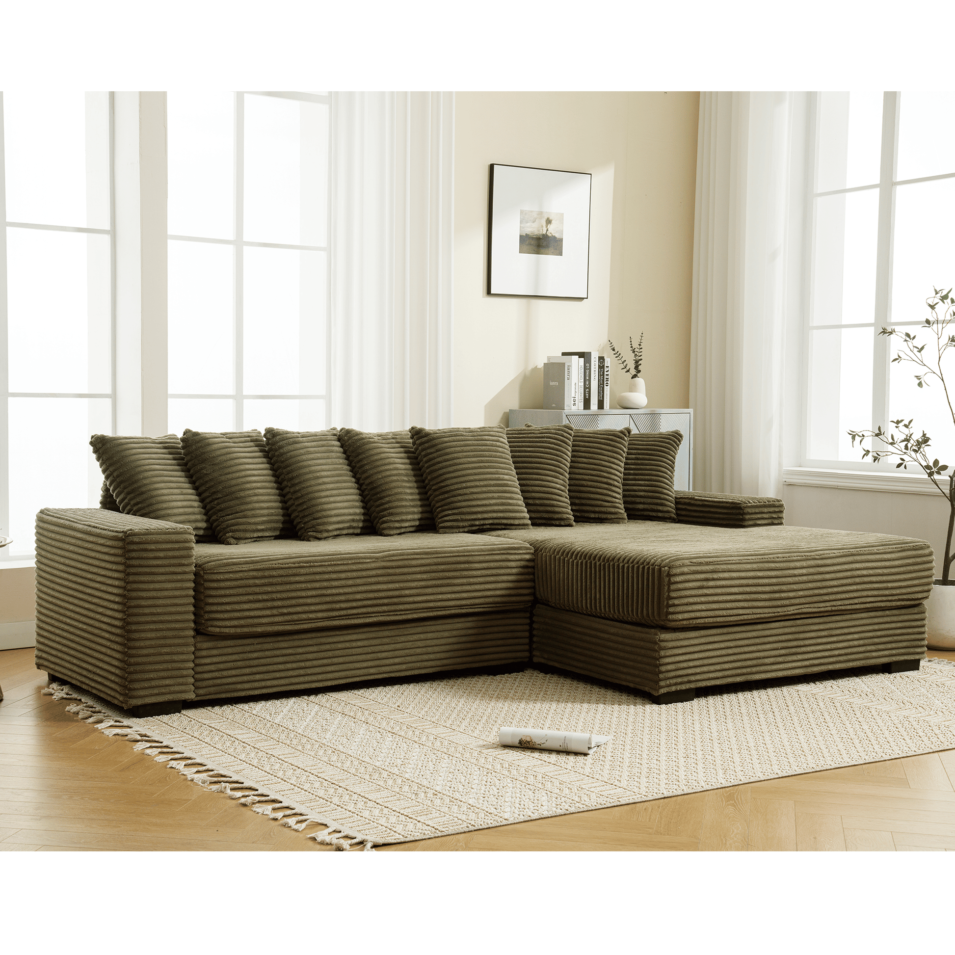 Doba oversized L-shaped corduroy sofa with right chaise and eight beige pillows in a living room.