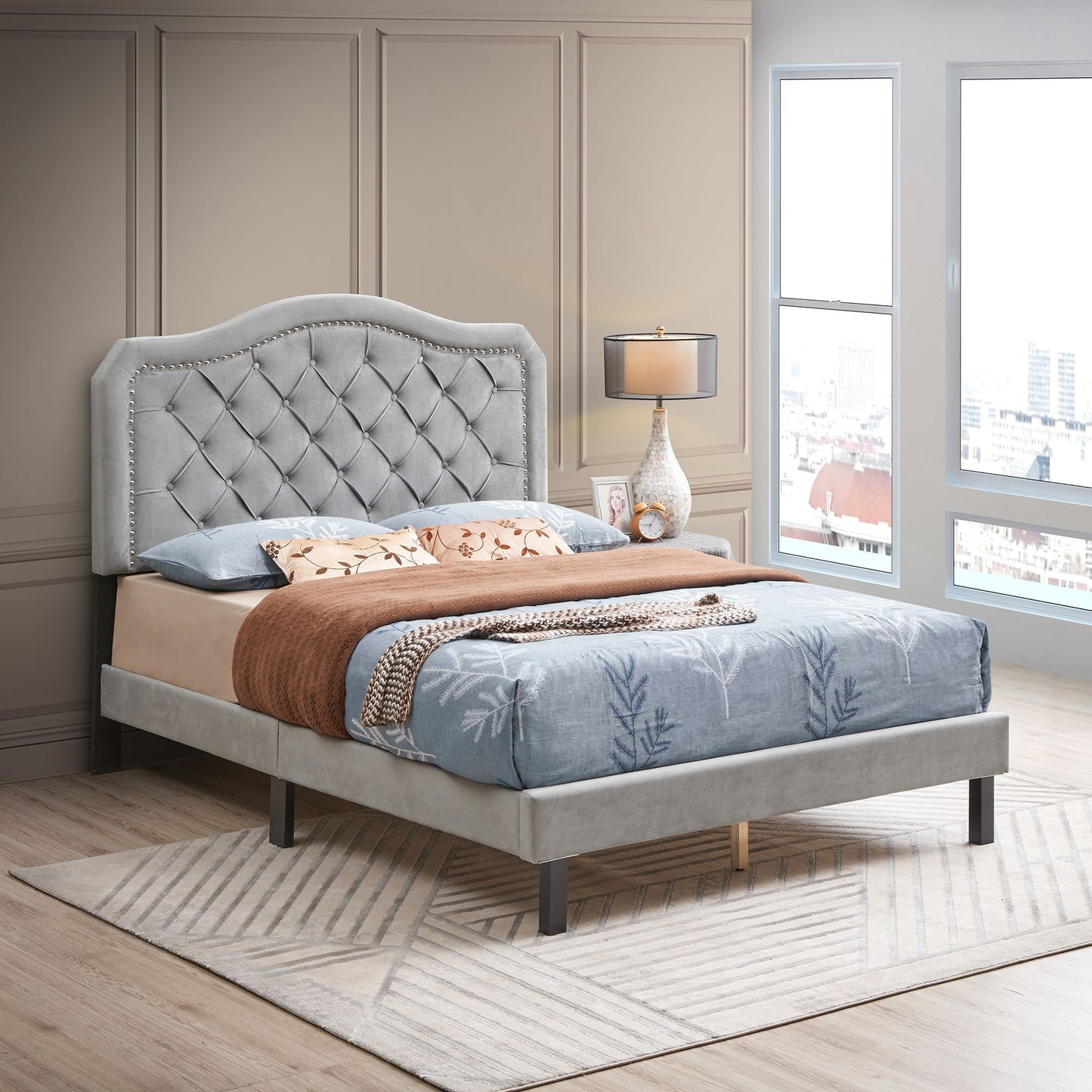 Upholstered bed with curved, button-tufted headboard and nailhead trim in gray velvet; queen size platform bed