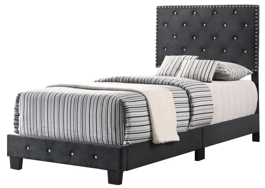 Twin bed with black tufted upholstered headboard, silver nailhead trim, and striped bedding