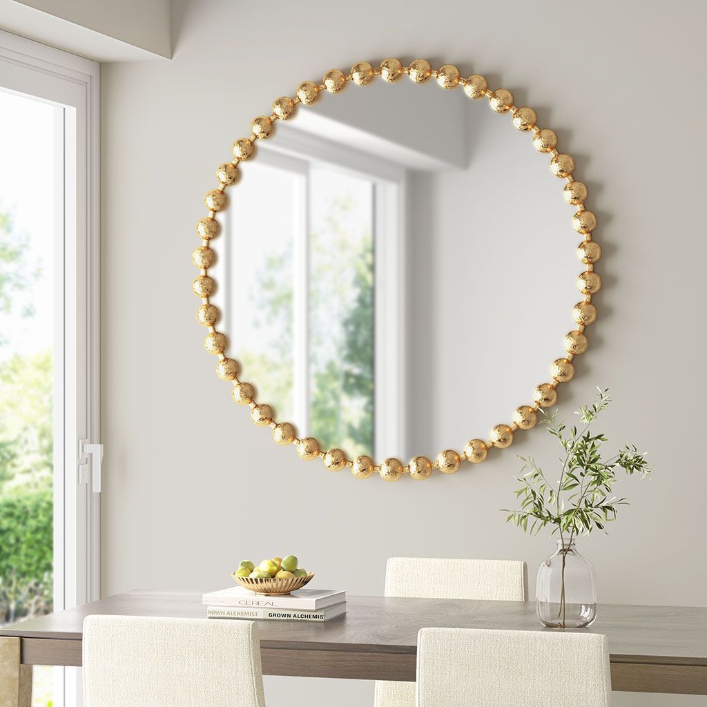 Beaded round wall mirror with gold bead frame, 36-inch diameter, displayed in a bright dining room with neutral decor.