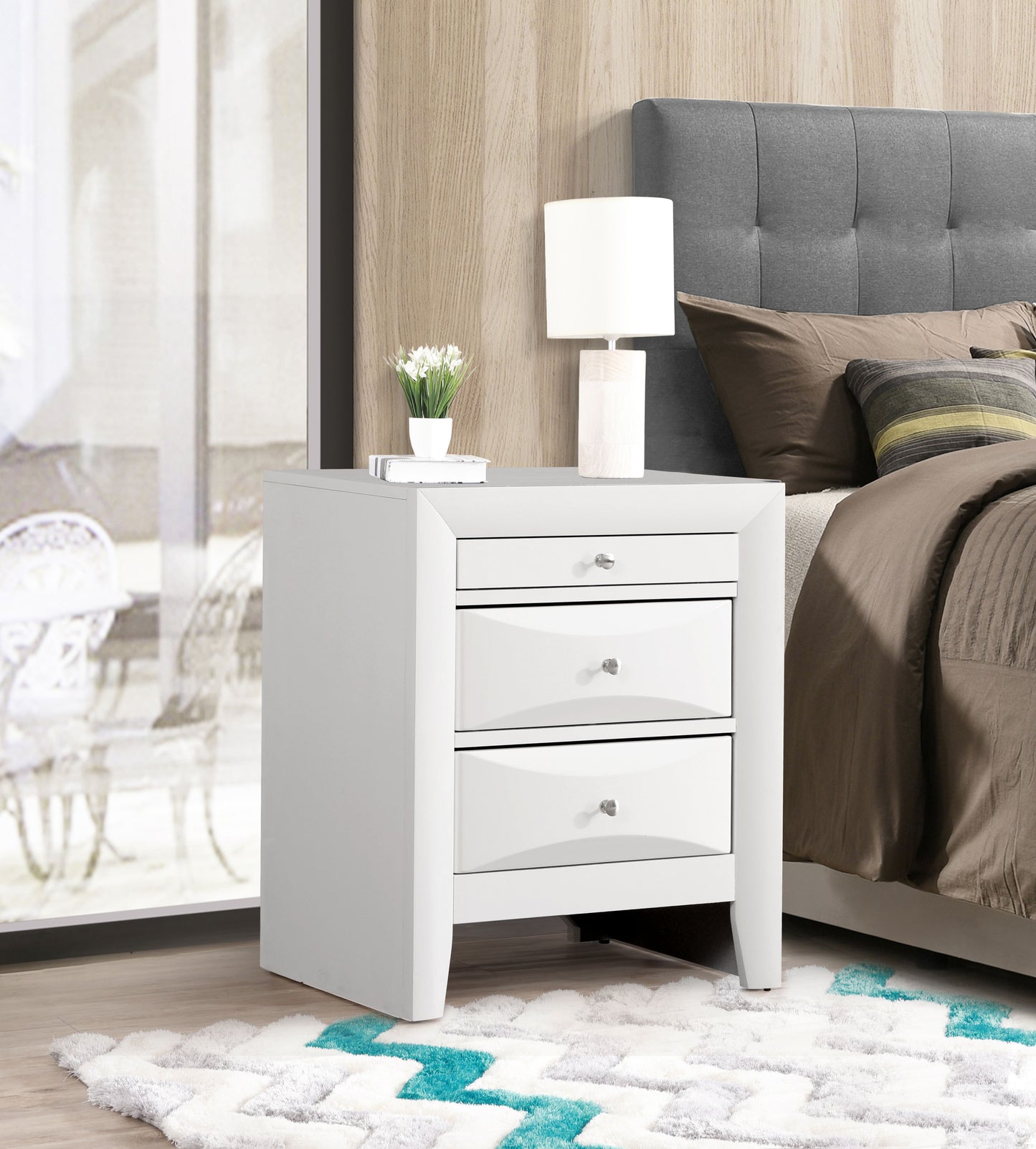 Elegant white nightstand with three drawers, modern bedside table in a contemporary bedroom with lamp and plant.