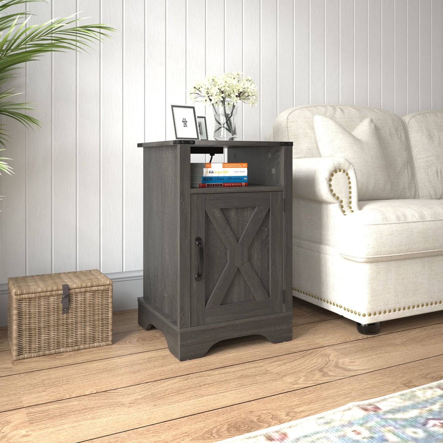 Farmhouse dark gray wooden nightstand with open shelf and cross-brace design beside a beige upholstered chair.